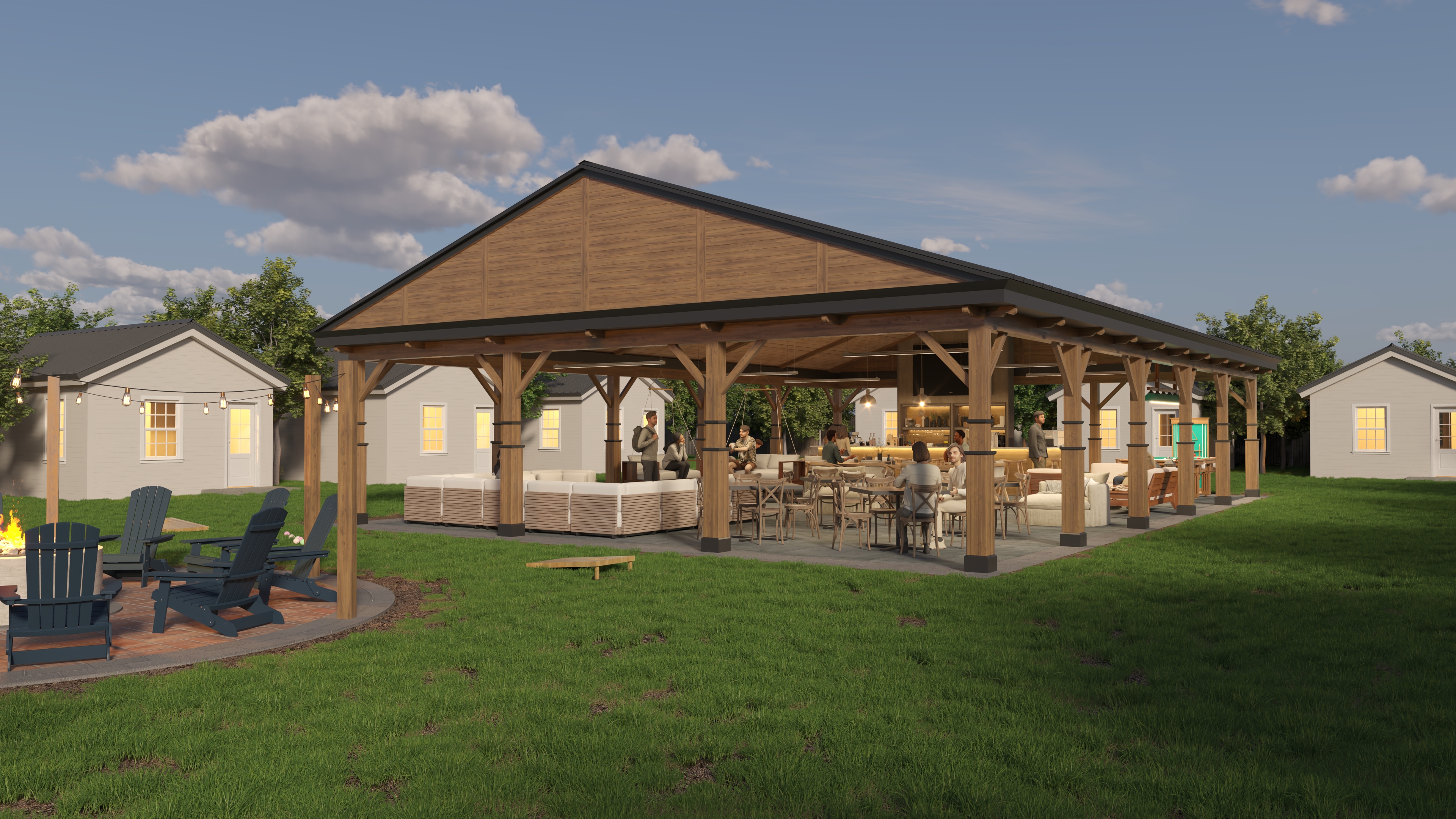 Guests relaxing outside a pavillion surrounded by cabins and trees